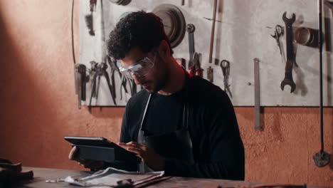 craftsman working on a tablet in a workshop