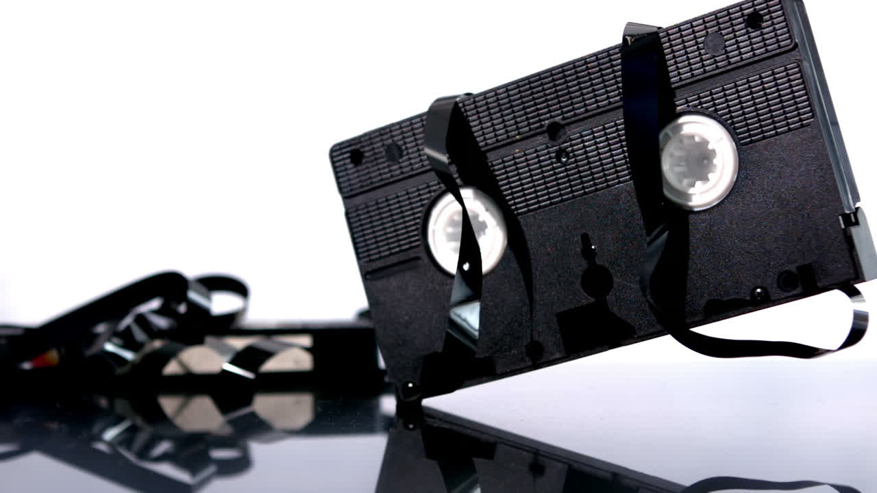 fita de vídeo caindo e saltando em fundo branco