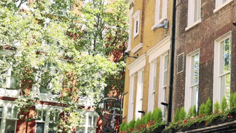 A picturesque view of a pub's exterior with vibrant greenery and bustling street activity.