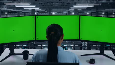 back view of asian woman working with mock up multiple computer monitor in data center