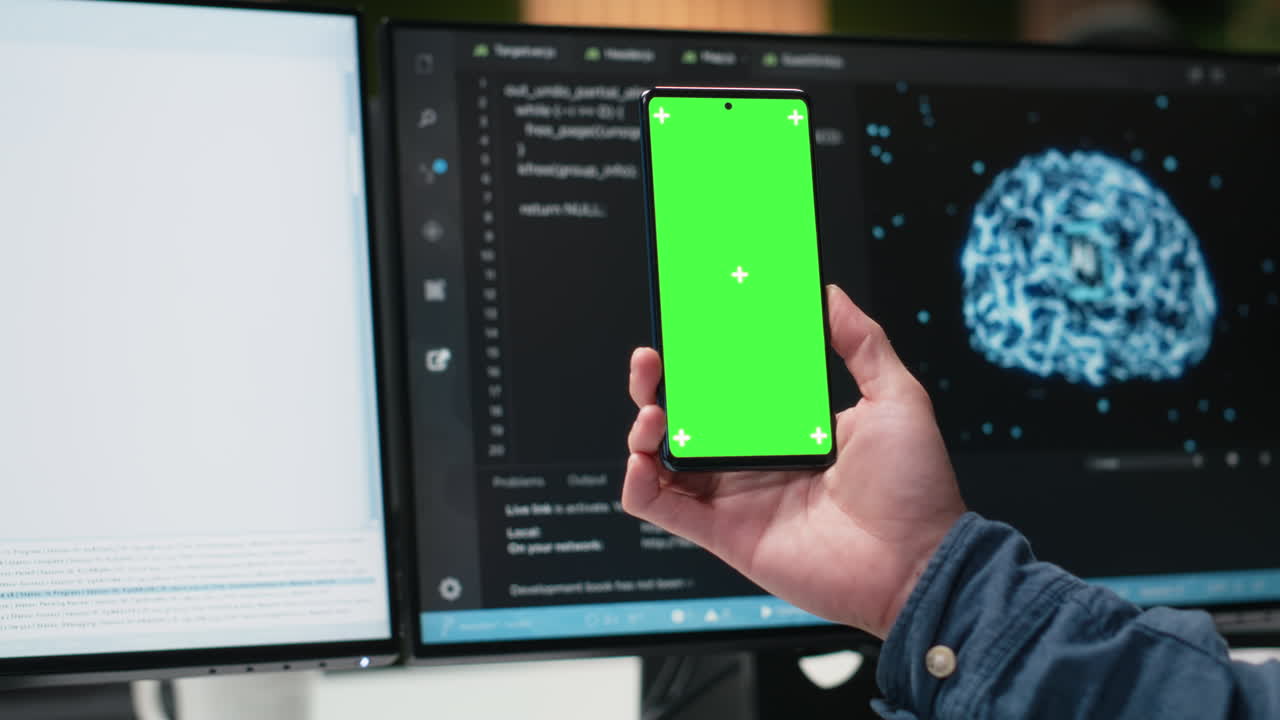 Hand Holding Green Screen Smartphone in Modern Tech Office