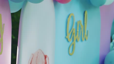 panning from boy to girl words from side view of gender reveal party backdrop