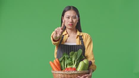 mujer rechazando una canasta de verduras