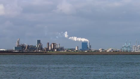 Mirando-A-Través-Del-Agua-Desde-El-Gancho-De-Holanda-Hacia-Fábricas,-Chimeneas-Y-Muelles,-Etc