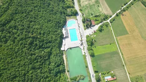 Swimming-pool-near-village,-aerial-view