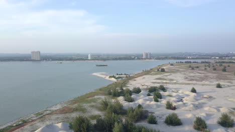 beautiful panoramic view of the melaka coastline, malaysia, with white sand in the foreground and city buildings in the background