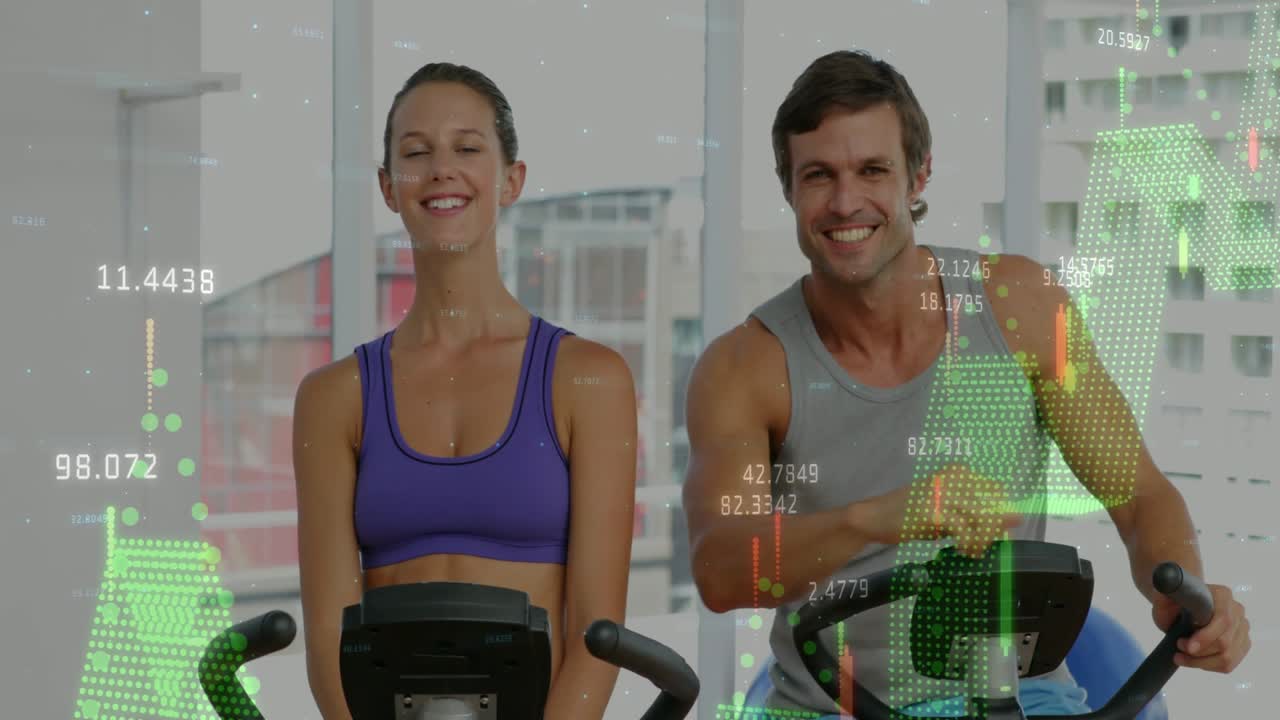 Woman and man pedaling in gym, overlaying financial charts to track progress, exchanging fist bump