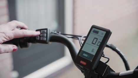 woman adjusts the speed compensation on a e-bike with the controls on the handle bar