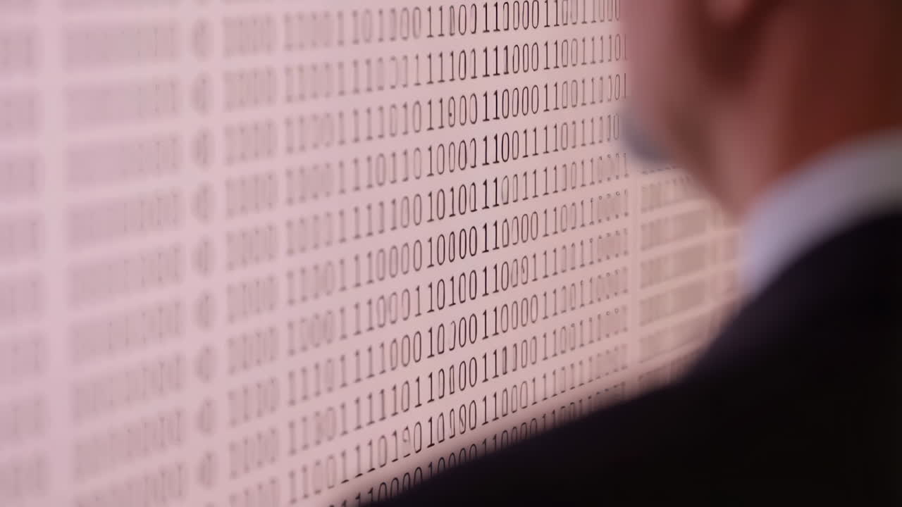 Person Observing Binary Code on a Digital Screen