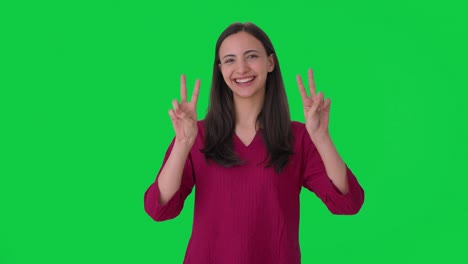 mujer india feliz mostrando el signo de la victoria pantalla verde