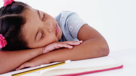 una colegiala cansada durmiendo en el libro