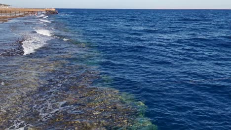 view of sea waves, rock and sand. sea shore water background