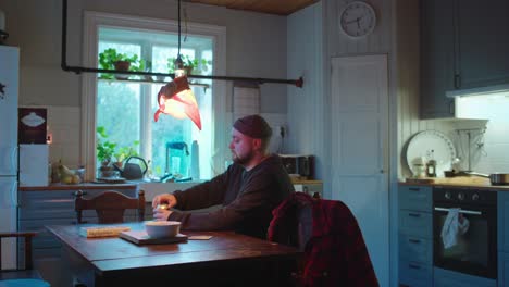 single taking a soda out of the fridge and reading in the kitchen