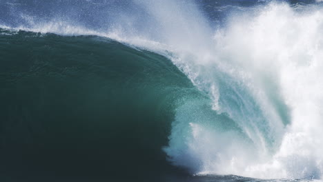 cresting wave crashes with thick spray and white foam in crisp high speed motion