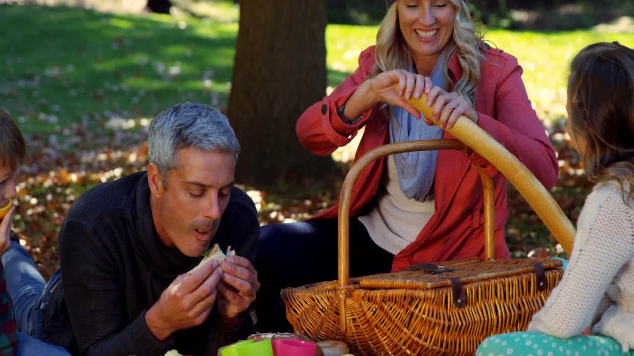 mujer cortando pan durante un picnic