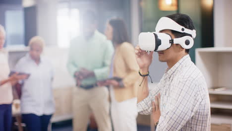 exploring virtual reality using vr headset, man while colleagues discuss in background