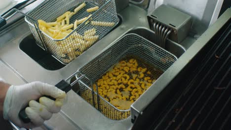 el cocinero agitando los anacardos en la rejilla de los alevines