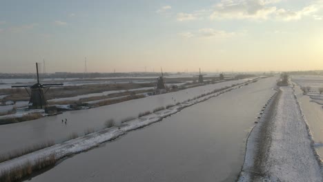 Winter-time-at-famous-Kinderdijk-windmills-with-frozen-river,-sunrise