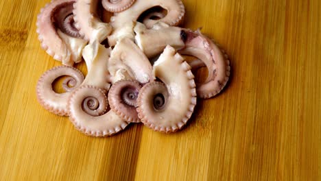 high angle shot of an arrangement of octopus tentacles rotating on a wooden surface