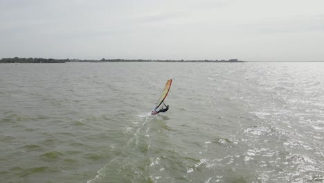 Drohnenaufnahme-Eines-Windsurfers-Mit-Voller-Geschwindigkeit-An-Einem-Windigen-Tag-In-Holland