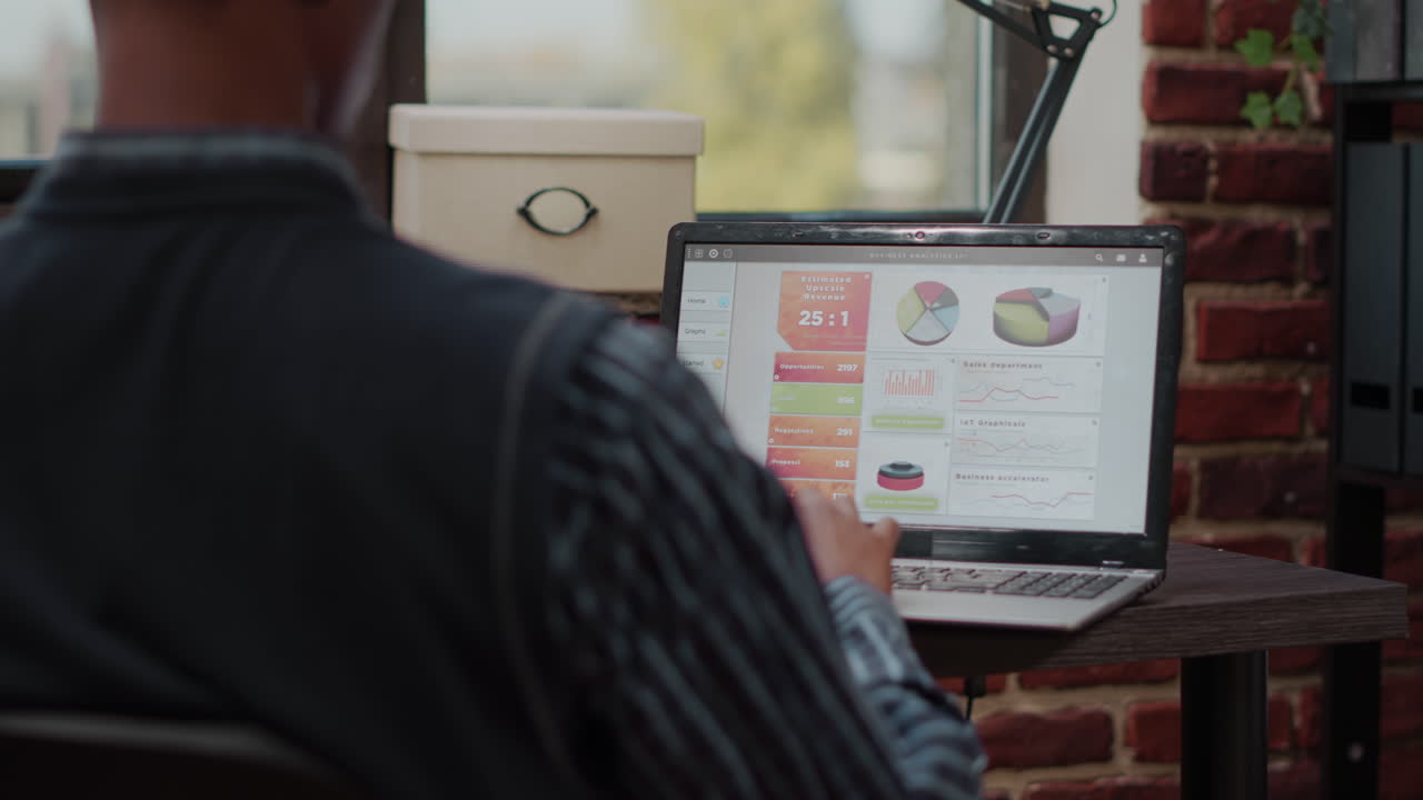 Sales assistant planning business charts on digital laptop