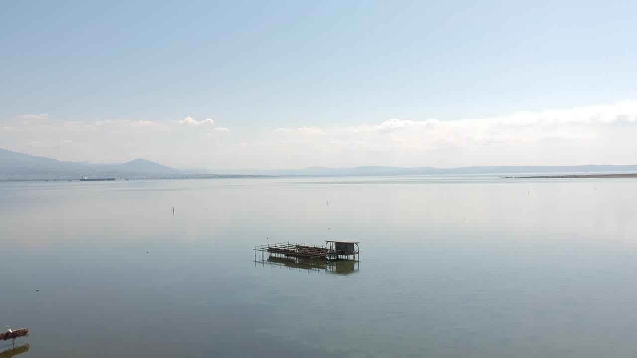 Forward moving drone shot over an ocean towards a fishing shack close to Axios river in Thessaloniki- Northern Greece