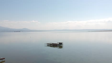 forward moving drone shot over an ocean towards a fishing shack close to axios river in thessaloniki- northern greece