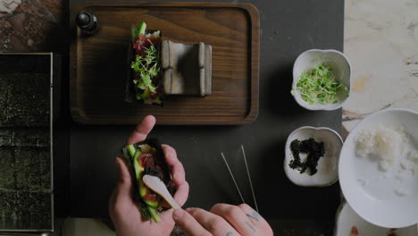 Von-Oben-Nach-Unten-Aufnahme-Eines-Kochs,-Der-Eine-Sushi-Handrolle-Zubereitet