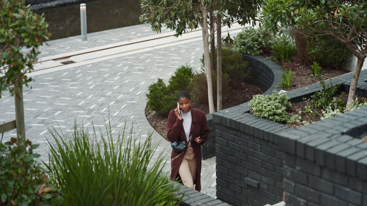 도시 거리를 고 있는 한 여성이 드폰으로 얘기하고 있습니다.