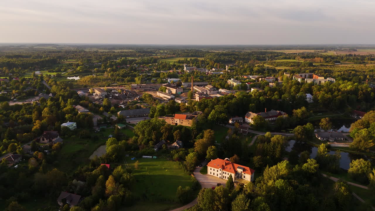 Aerial rising over picturesque town of Aizpute at golden hour, Latvia