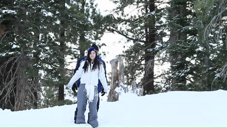 una pareja joven juega en la nieve