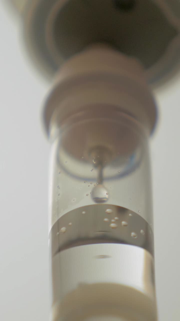 Primo piano di flebo medica con gocce di liquido che cadono