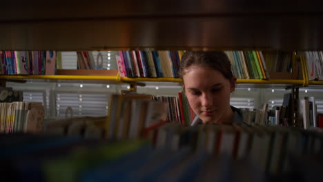 Girl-in-a-library,-taking-and-putting-back-books-on-bookshelves,-handheld-shot