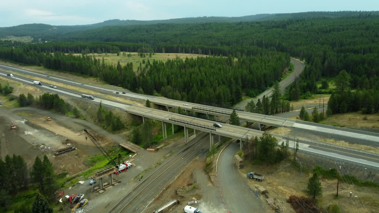 US, Oregon, Meacham, 2025-08-03 - Drone view of the construction of a new bridge going over a railroad in the mountains, next to I84