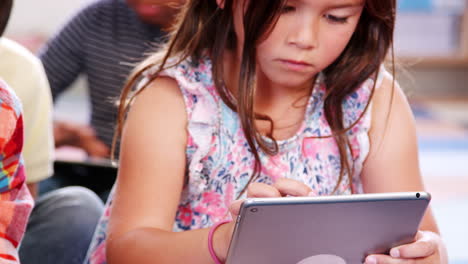 dos alumnos de escuela primaria que usan tabletas en clase
