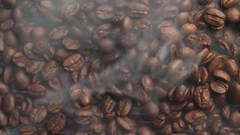 top view of roasted coffee beans with smoke, video in 4k, 50fps