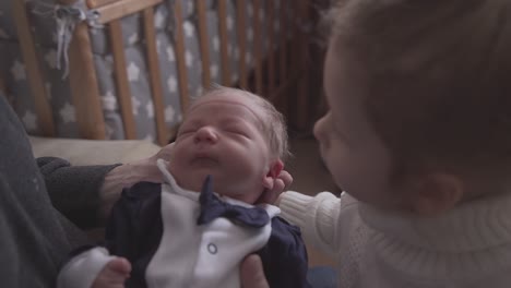 pretty girl kisses junior brother in tuxedo in father arms