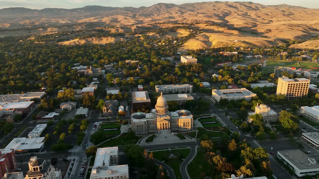 Aerial of Idaho State Capitol Building in downtown Boise at sunset with foothills background