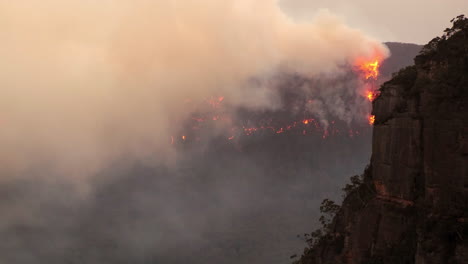 Australisches-Buschfeuer-Mit-Extremem-Rauch-Und-Sichtbaren-Flammen,-Die-Einen-Kamm-In-Den-Blauen-Bergen-Verbrennen