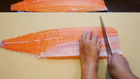 a chef making partitioning salmon for packing and refrigeration