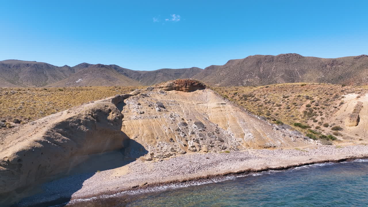 Rapido primo piano aereo di una scogliera angolata e una formazione rocciosa sul litorale, Almería, Spagna.
