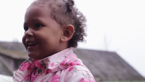 retrato de una alegre niña africana mirando alrededor en el fondo del campo