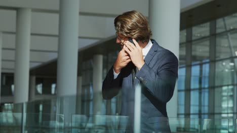 Geschäftsmann-Auf-Smartphone-In-Einem-Modernen-Bürogebäude