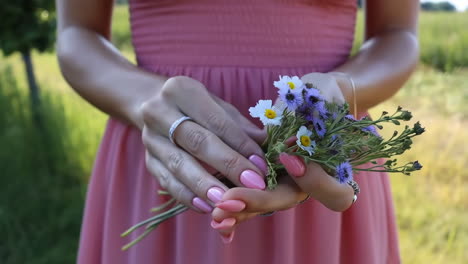 woman holding a small bouquet of wildflowers