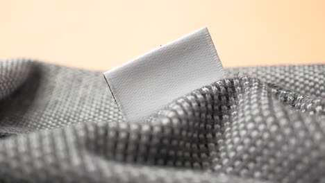 blank clothing tag on gray knitted fabric