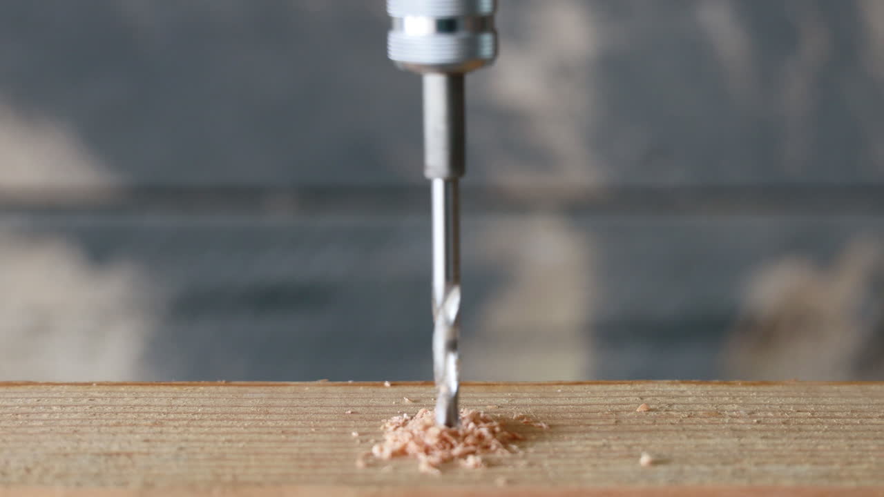 A drill bit drilling a hole into a piece of wood
