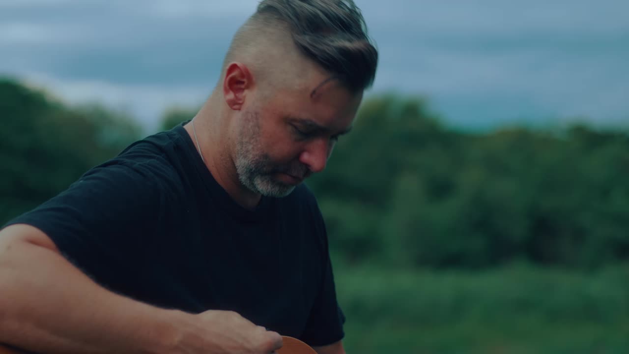 Man playing acoustic guitar outdoors
