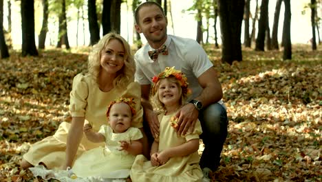 happy young family with their children spending time outdoor in the autumn park