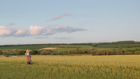 a middle-aged woman enjoys a walk in a scenic area near a wheat field