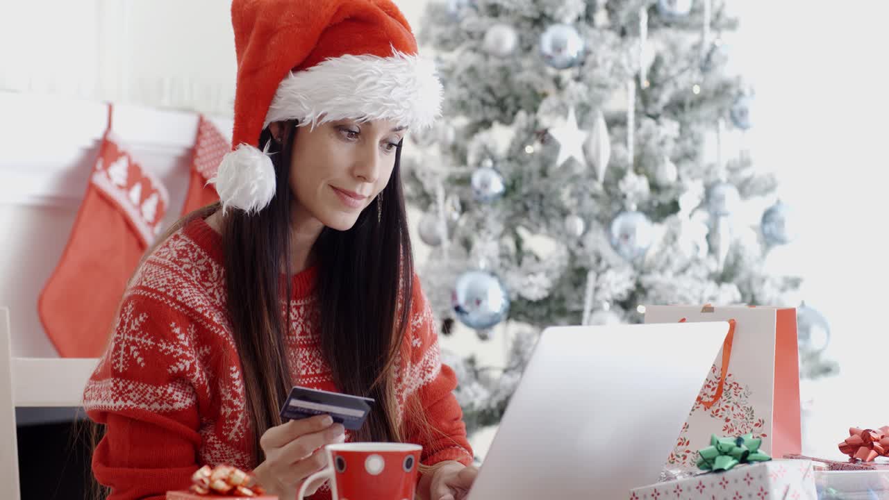 una mujer joven ordenando regalos de navidad en línea.